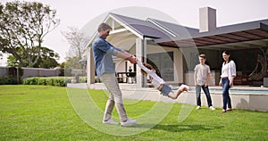 Family, home and bonding while having fun and playing outside on their backyard lawn. Happy father spinning and swinging