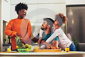 Family at home eating breakfast in kitchen together