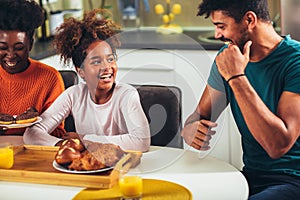 Family at home eating breakfast in kitchen together