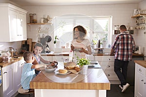 Family At Home Eating Breakfast In Kitchen Together