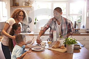 Family At Home Eating Breakfast In Kitchen Together