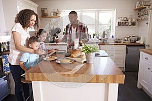 Family At Home Eating Breakfast In Kitchen Together