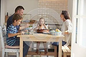 Family At Home In Eating Meal Together