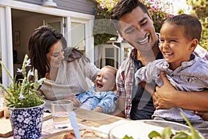 Family At Home Eating Outdoor Meal In Garden Together