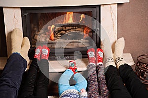 Family at home. Feet in socks near fireplace. Winter holiday concept