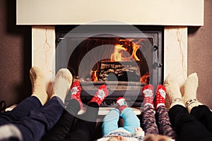 Family at home. Feet in socks near fireplace. Winter holiday concept