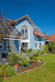 Family home with photovoltaic panels, backyard garden