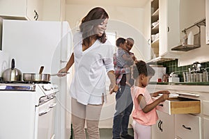 Family At Home Preparing Meal In Kitchen Together