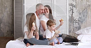 The family at home on self-isolation eat pizza and watch cartoons on a laptop