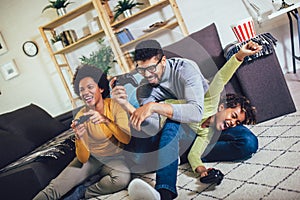 Family at home sitting in sofa couch and playing console video games together