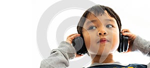 Family, home, technology and music concept. Portrait Young little Asian boy listening music with headphones at home. School child