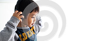 Family, home, technology and music concept. Portrait Young little Asian boy listening music with headphones at home. School child