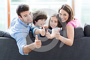 Family at home with thumbs up