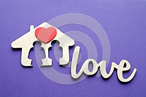 Family house with red heart over ultraviolet background