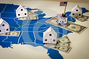 Family houses with dollar bills and central goverment tax over a US map