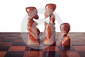 Family with husband , wife and a son, represented by three pieces of wooden chess, king, queen and pawn , facing each other. photo