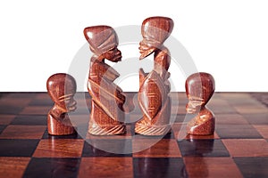 Family with husband, wife and two children, represented by four pieces of wooden chess king, queen and two pawns photo