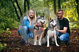 Family with husky dogs in the forest