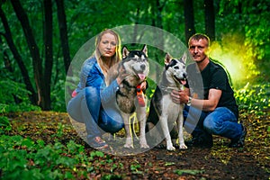 Family with husky dogs in the forest