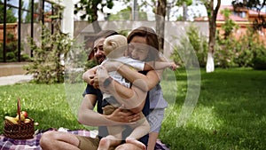 Family idyll. Happy child running to his parents in a blurred perspective. Close up of young couple hugging his little