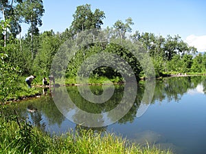 Family investigating a fishing pond