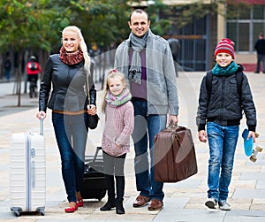 Family journey: spouses with children walking and luggage