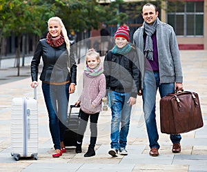 Family journey: spouses with children walking and luggage