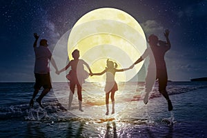 Family jumping on beach and watching the moon.Celebrate Mid autumn festival concept