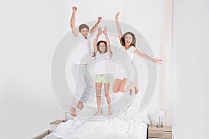 Family Jumping On Bed Together