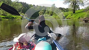 Family kayak trip. Mom and daughter rowing a boat on the river, a water hike, a summer adventure. Eco-friendly and extreme tourism