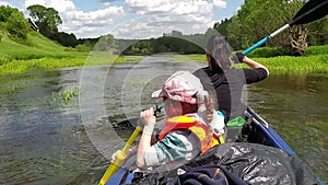 Family kayak trip. Mom and daughter rowing a boat on the river, a water hike, a summer adventure. Eco-friendly and extreme tourism