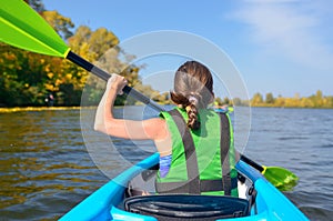 Family kayaking, child paddling in kayak on river canoe tour, kid on active autumn weekend and vacation