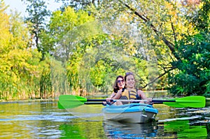 Family kayaking, mother and child paddling in kayak on river canoe tour, active autumn weekend and vacation, sport and fitness