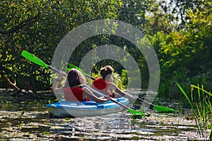 Family kayaking, mother and child paddling in kayak on river canoe tour, active autumn weekend and vacation, sport and fitness