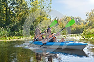 Family kayaking, mother and child paddling in kayak on river canoe tour, active autumn weekend and vacation, sport and fitness