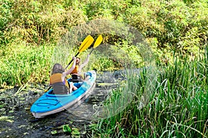 Family kayaking, mother and child paddling in kayak on river canoe tour, active summer weekend and vacation