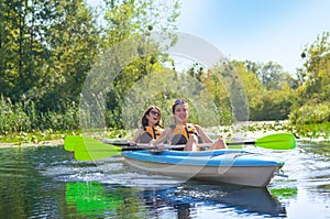 Family kayaking, mother and daughter paddling in kayak on river canoe tour having fun, active autumn weekend