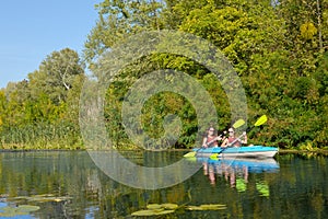 Family kayaking, mother and daughter paddling in kayak on river canoe tour having fun, active autumn weekend