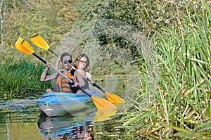 Family kayaking, mother and daughter paddling in kayak on river canoe tour having fun, active weekend and vacation with children