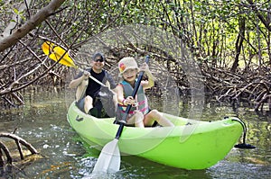 Family kayaking through tropical mangrove Forest