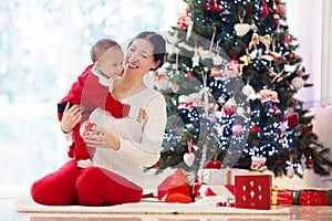 Family with kids at Christmas tree and fireplace