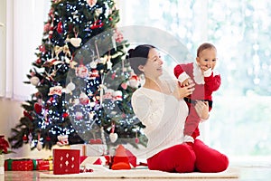 Family with kids at Christmas tree and fireplace