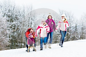 Family with kids having winter walk in snow