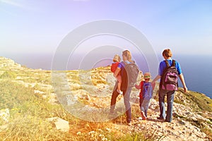 Family with kids hiking in summer mountains