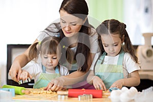 Family kids and mother baking cookies in kitchen together