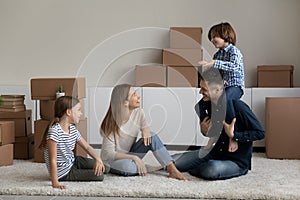 Family with kids resting sit on floor on relocation day