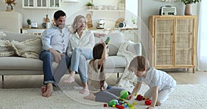 Family with kids spend leisure together in cozy living room