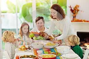 Family with kids at Thanksgiving dinner. Turkey