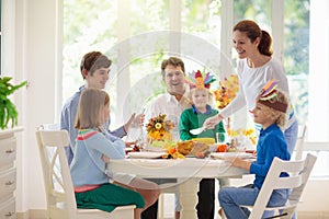 Family with kids at Thanksgiving dinner. Turkey