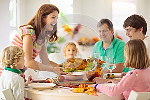 Family with kids at Thanksgiving dinner. Turkey